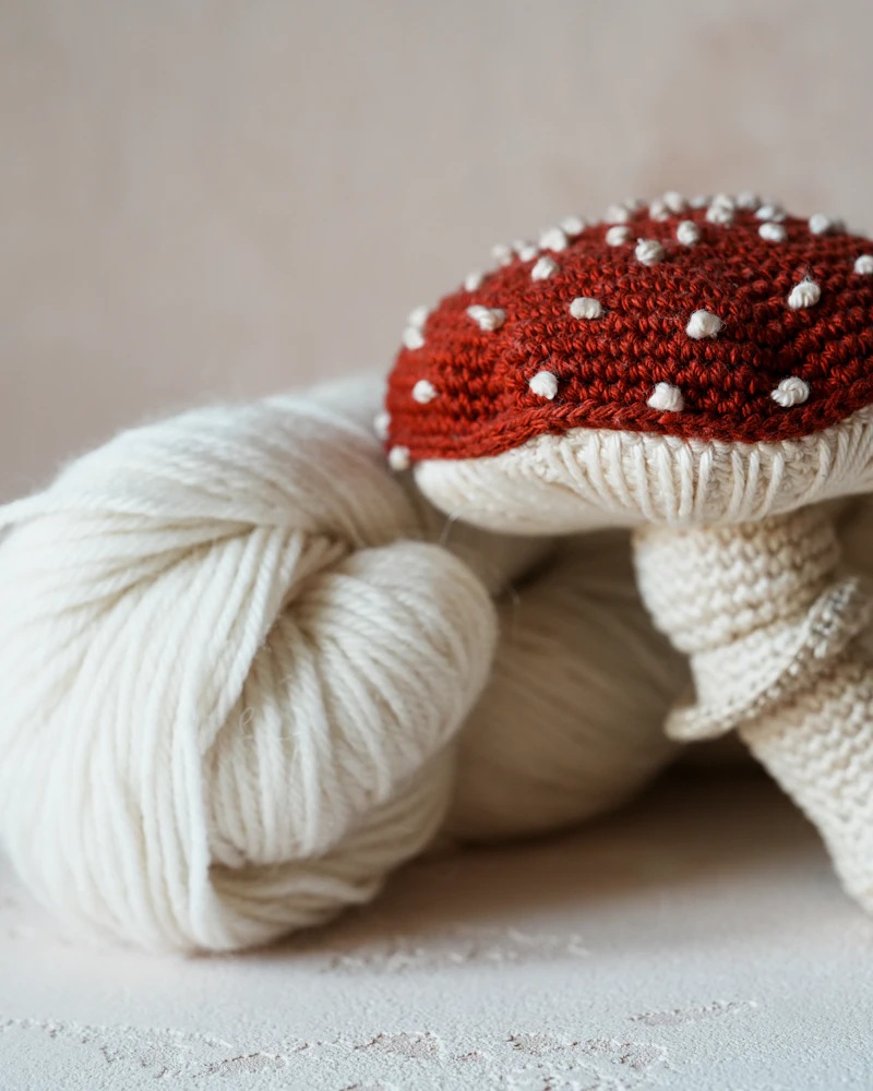 Crocheted red mushroom with yarn ball