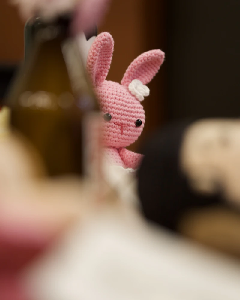 Small pink crocheted bunny on a wooden table