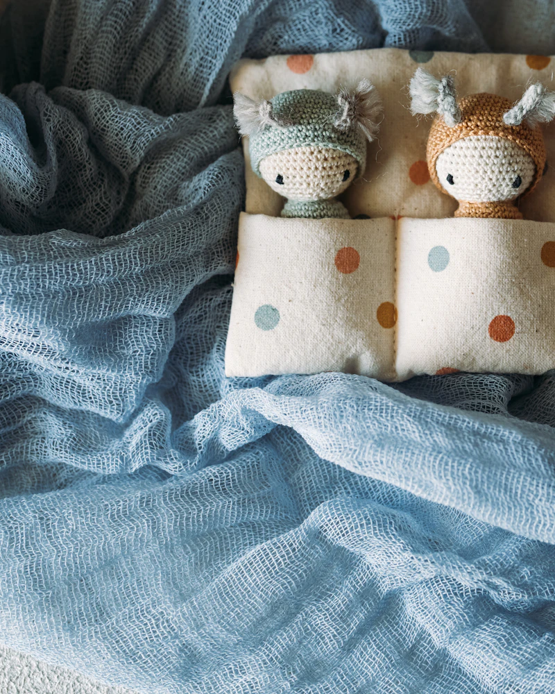 Three crocheted figures on polka-dot cushions